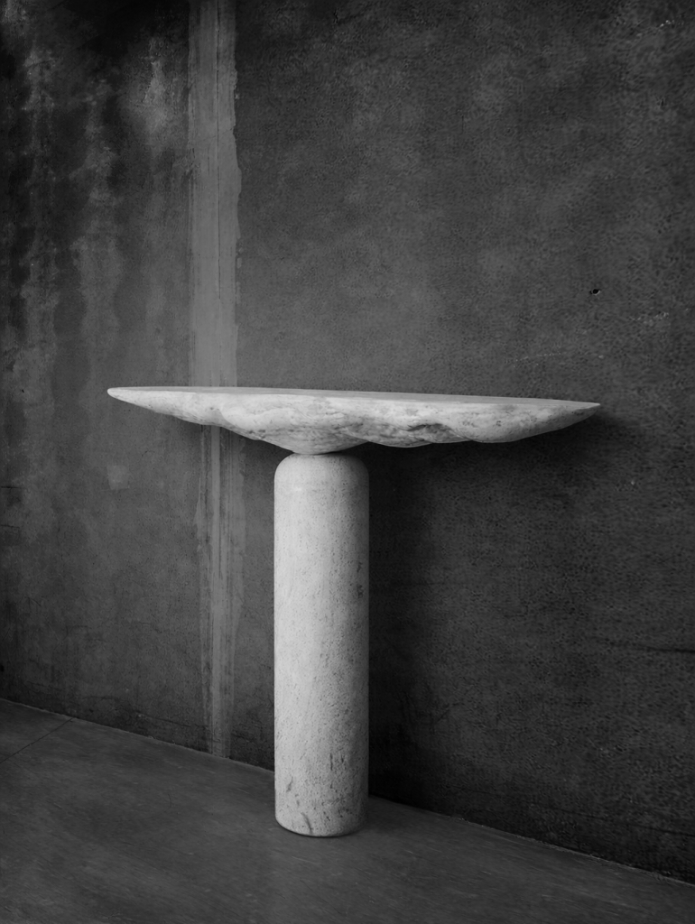 Contemporary sculptural stone table by Isac Elam Kaid from the Fragment series with axial balance and monolithic form.