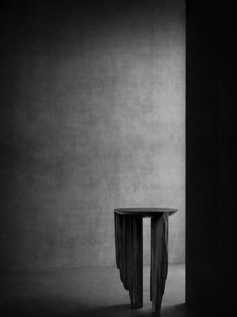 Sculptural table by Isac Elam Kaid formed from ebonized reclaimed timber with fractured vertical supports