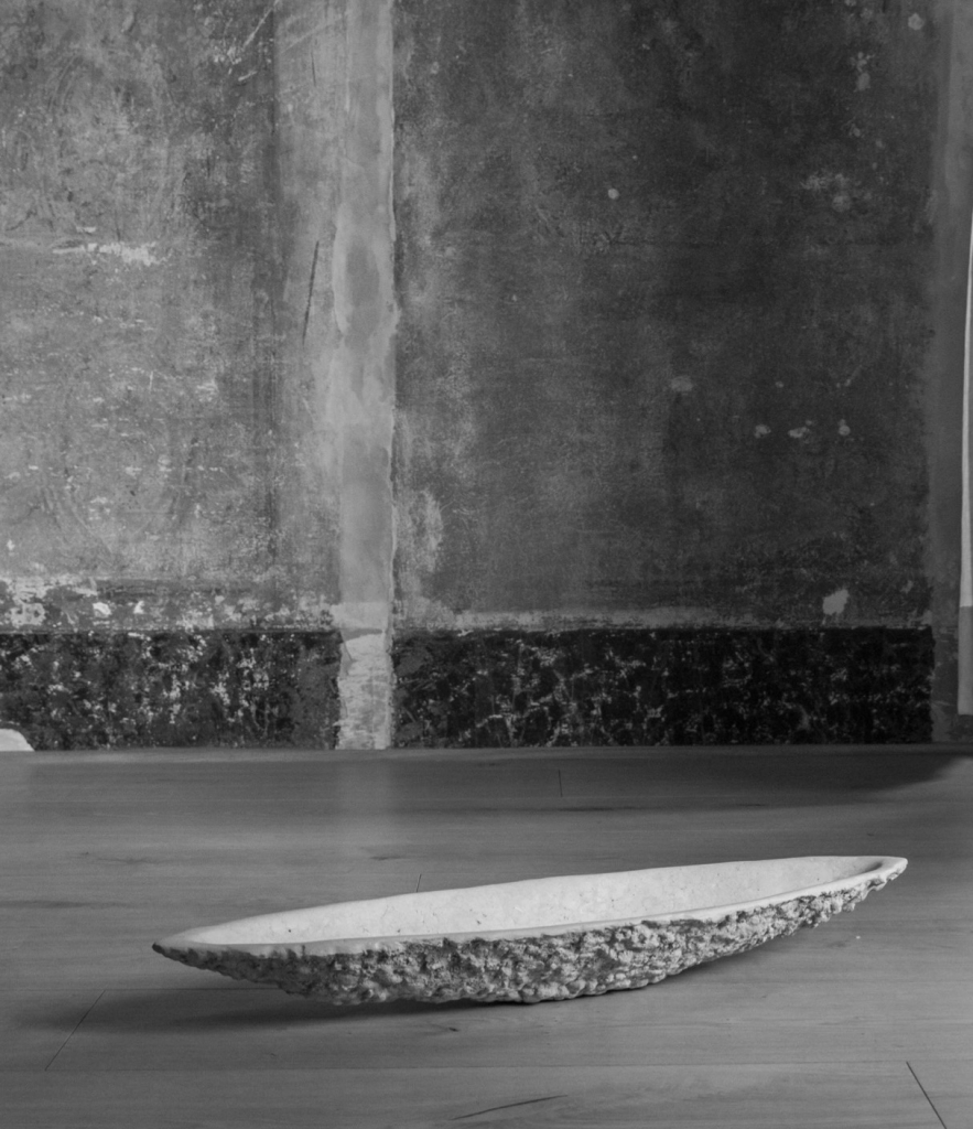 K2130 sculptural stone vessel by Isac Elam Kaid with fractured perimeter and shallow basin form.