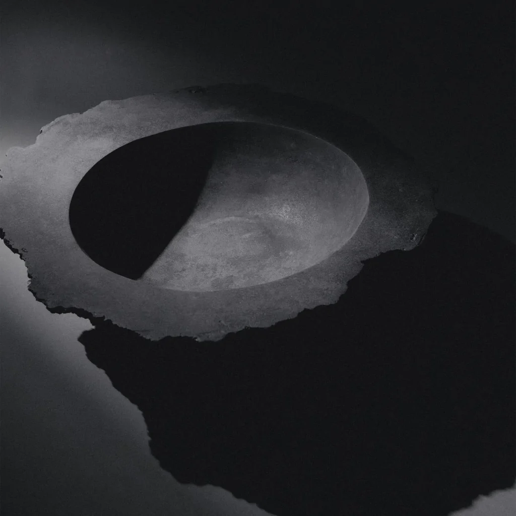 Fractured bronze vessel sculpture K25-2203 by Isac Elam Kaid showing rough exterior perimeter and smooth interior basin.